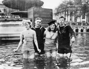 VE DAY CELEBRATIONS IN LONDON, ENGLAND, 8 MAY 1945 (EA 65799) Two British sailors and their girlfriends wading in the fountains in Trafalgar Square on VE Day. Copyright: © IWM. Original Source: http://www.iwm.org.uk/collections/item/object/205125103